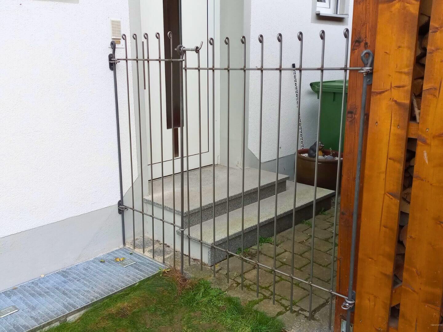 Gartenzaun Graz 145 in Eisen roh mit Tuer auf zwischen 2 Mauern montiert